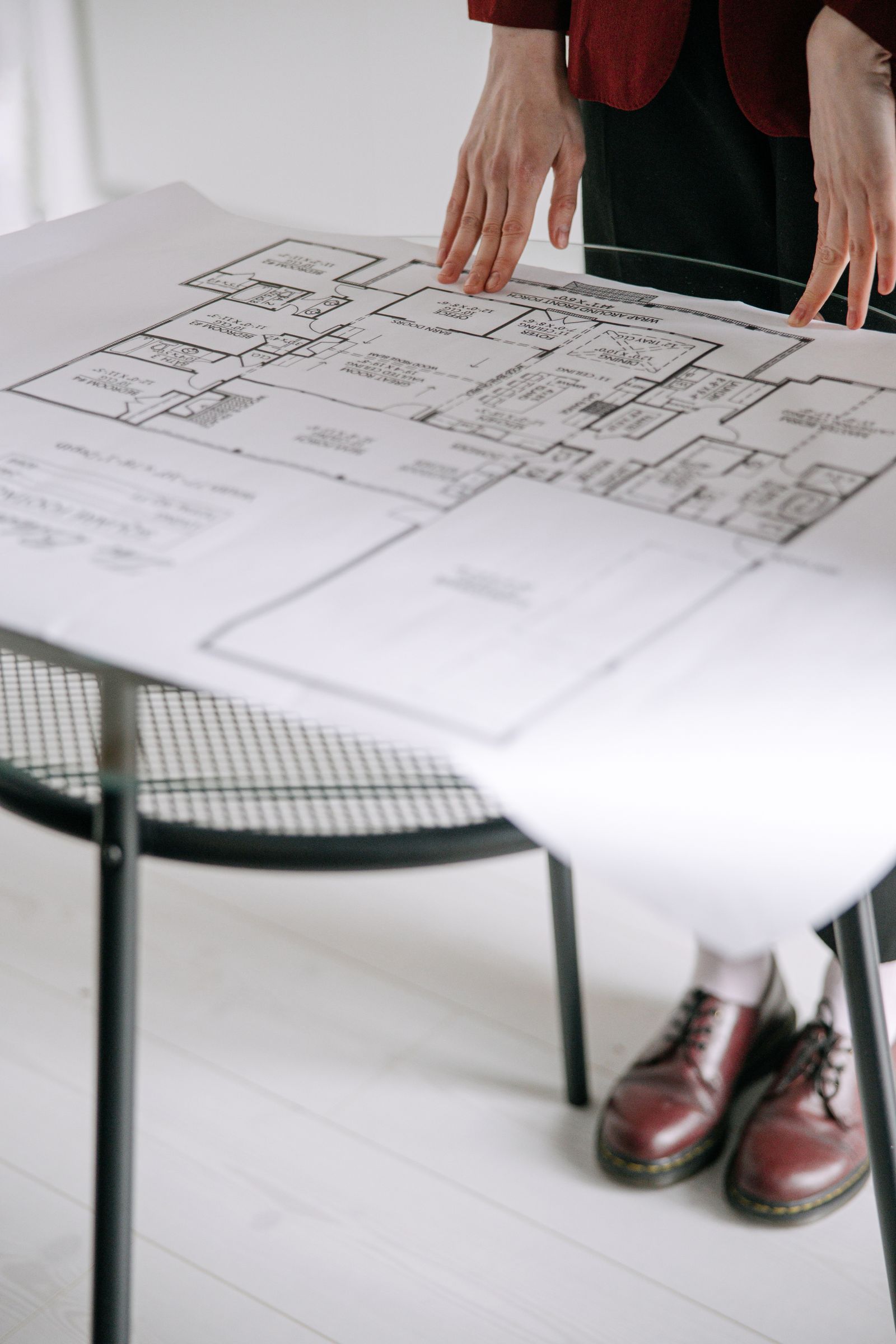 Person reviews an architectural floor plan on a table
