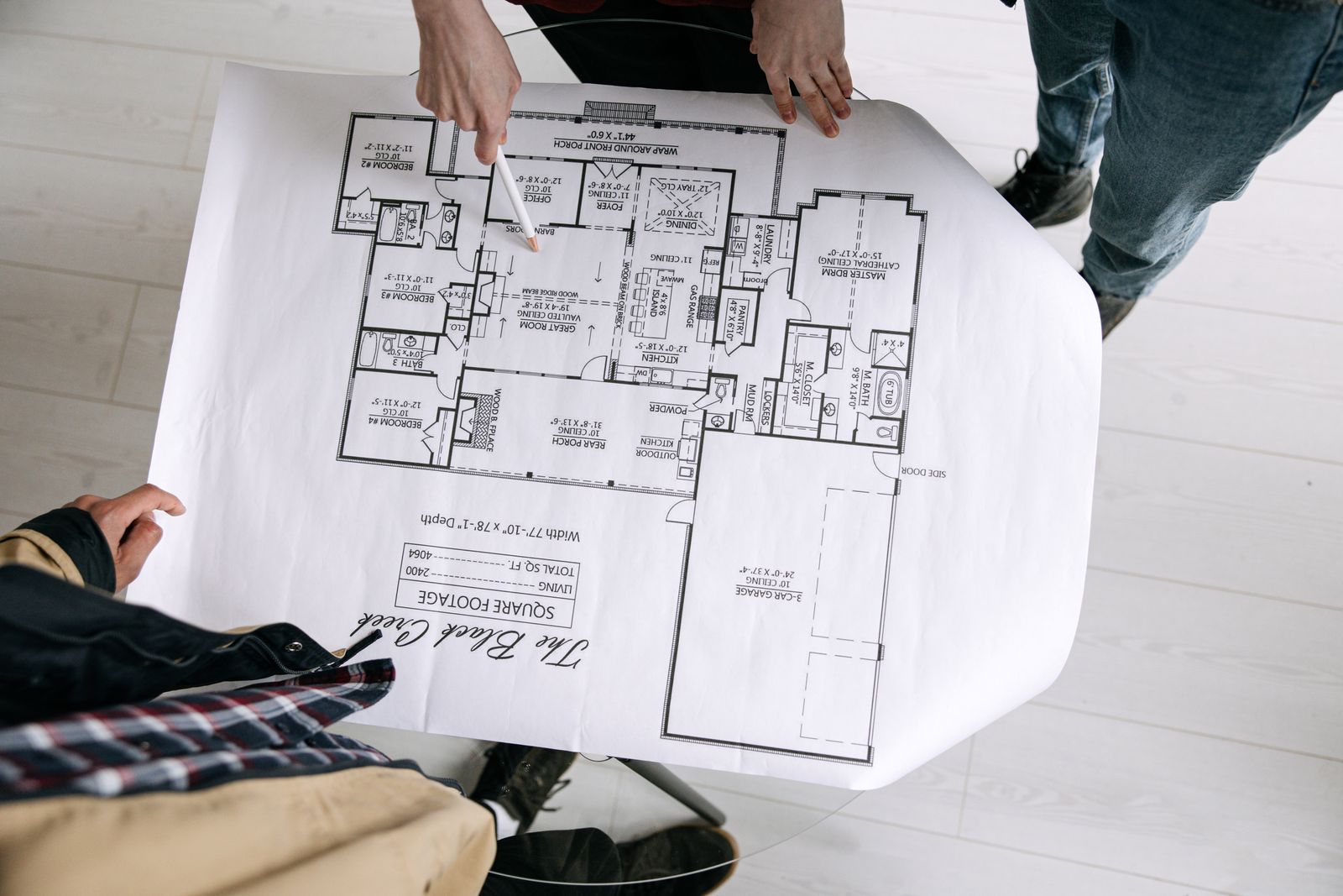 Two people examine an architectural plan on a table
