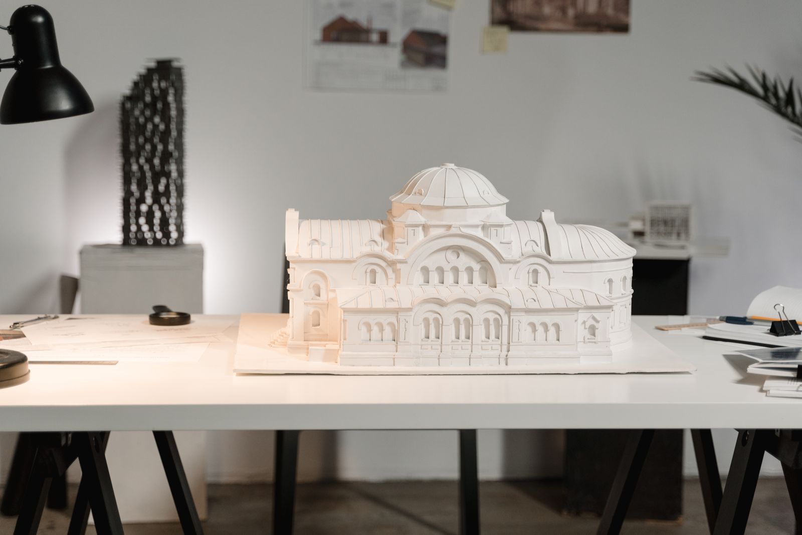 White physical architectural model with domes and arches on a drawing table