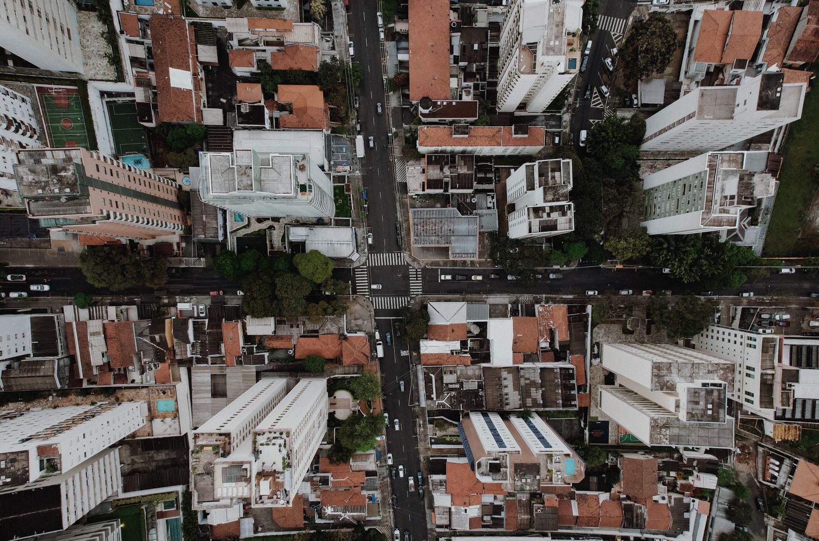 Top-down aerial photograph of a city intersection surrounded by buildings and trees