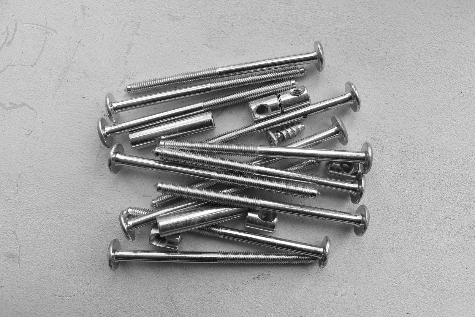 Cylindrical metal fasteners with circular holes arranged on a pale surface