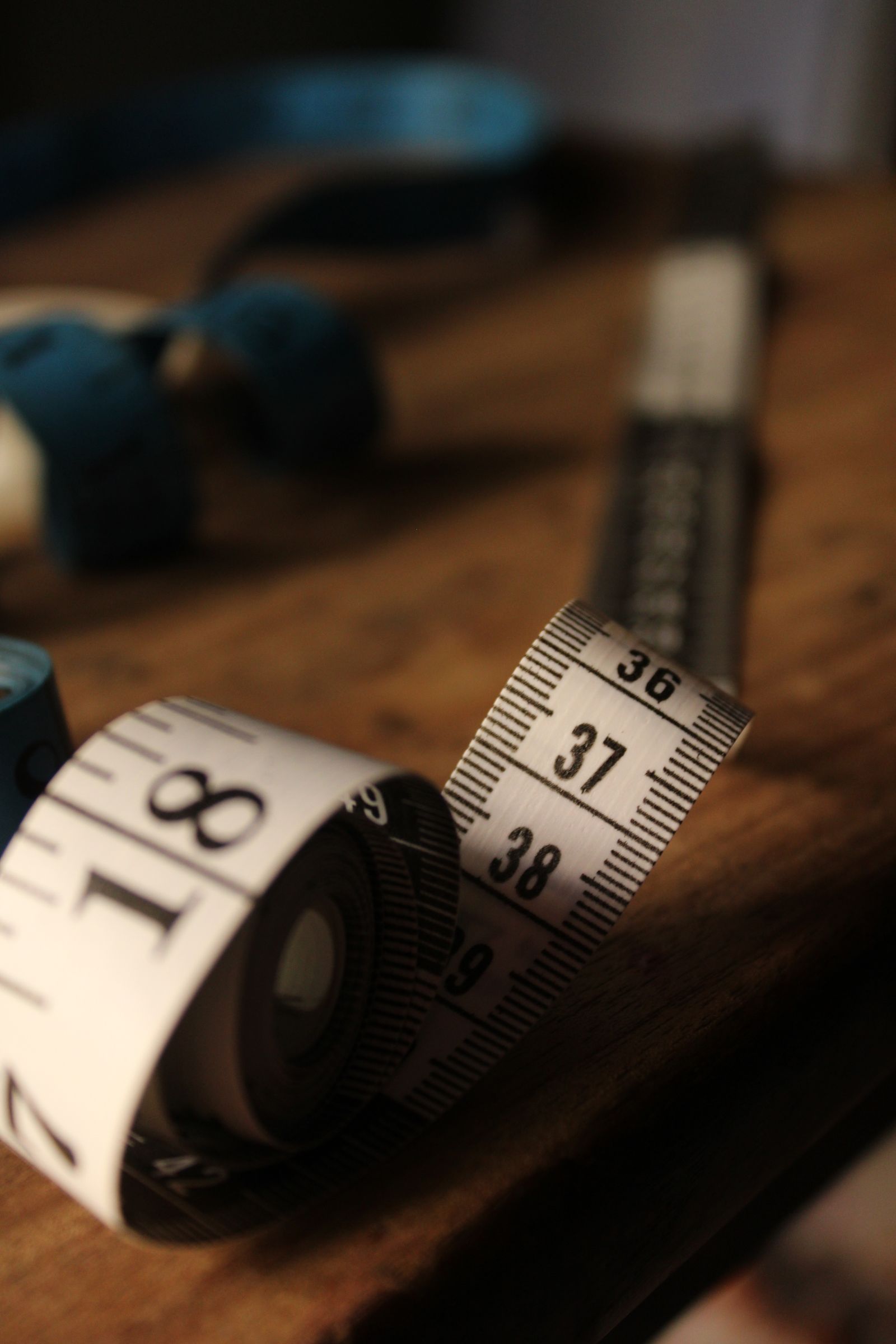 Rolled measuring tape resting on a wooden surface