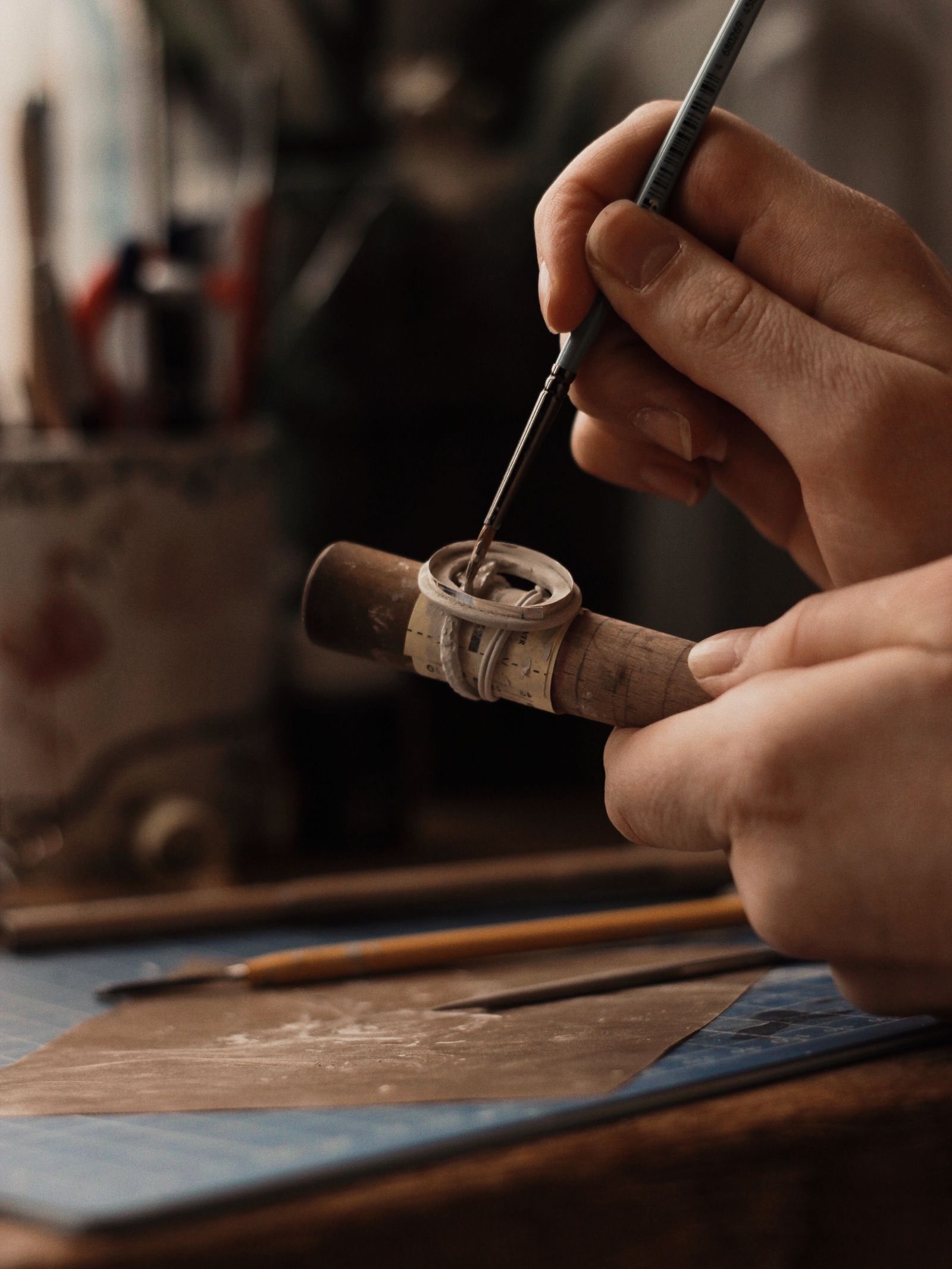 Jeweler holds a small metal ring with hand tools