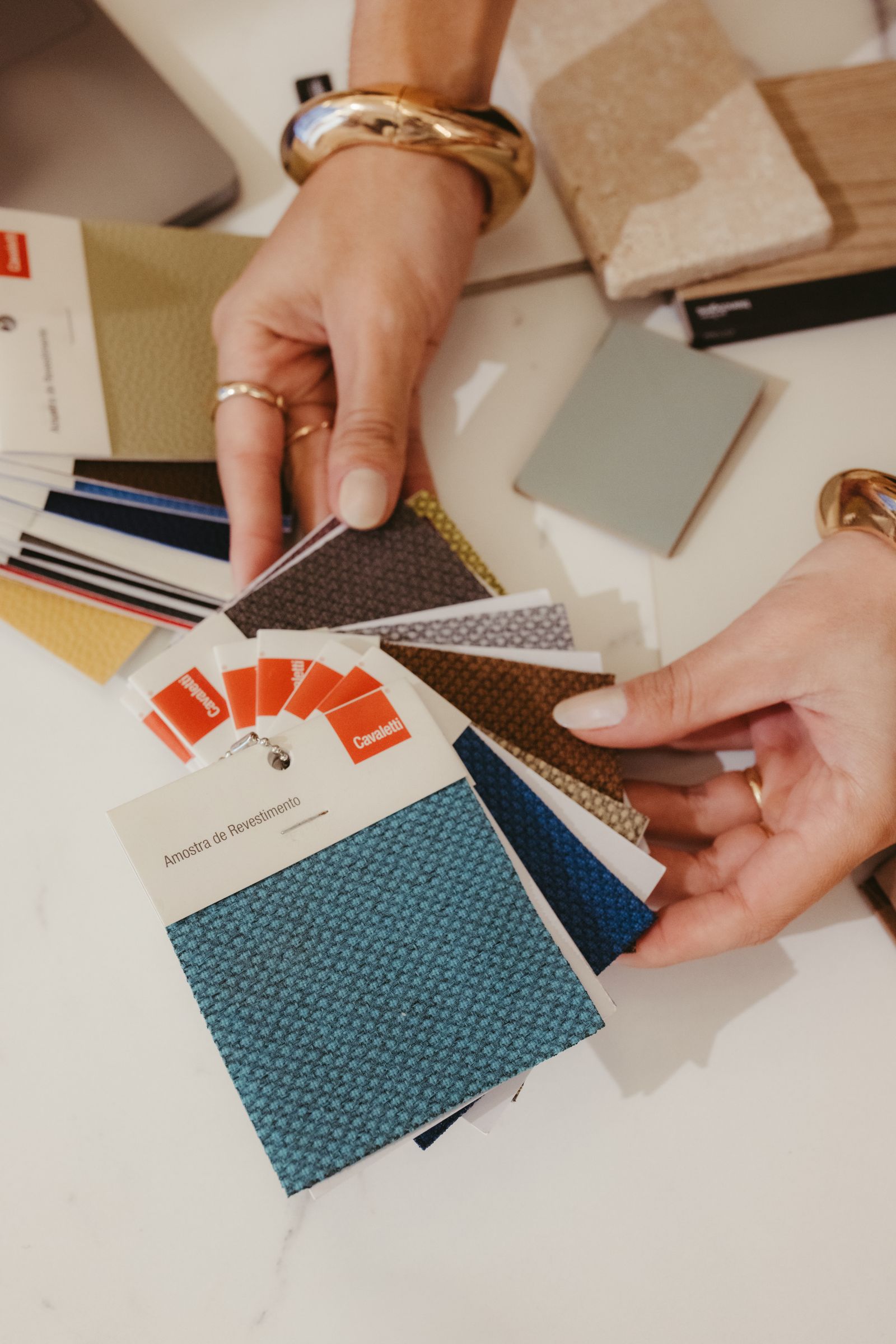 Hands hold a fan of fabric swatches in different colors