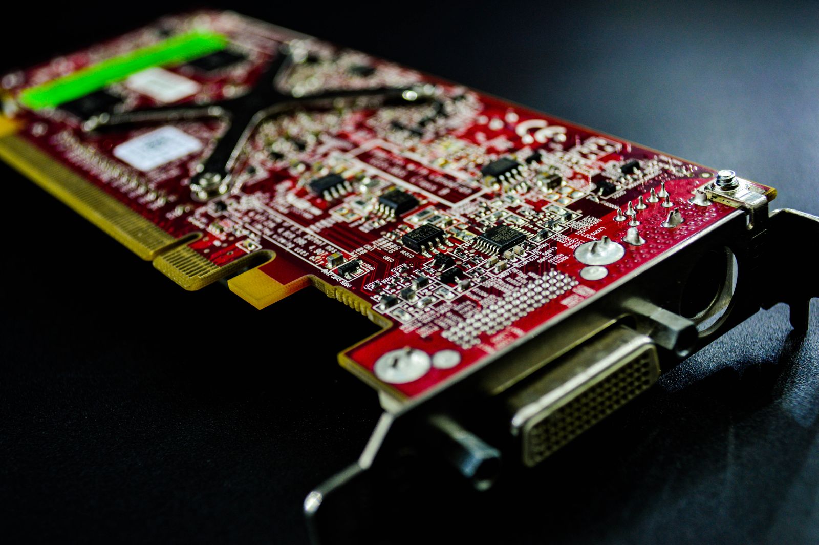 Red electronic circuit board with visible chips, connectors and mounting hardware