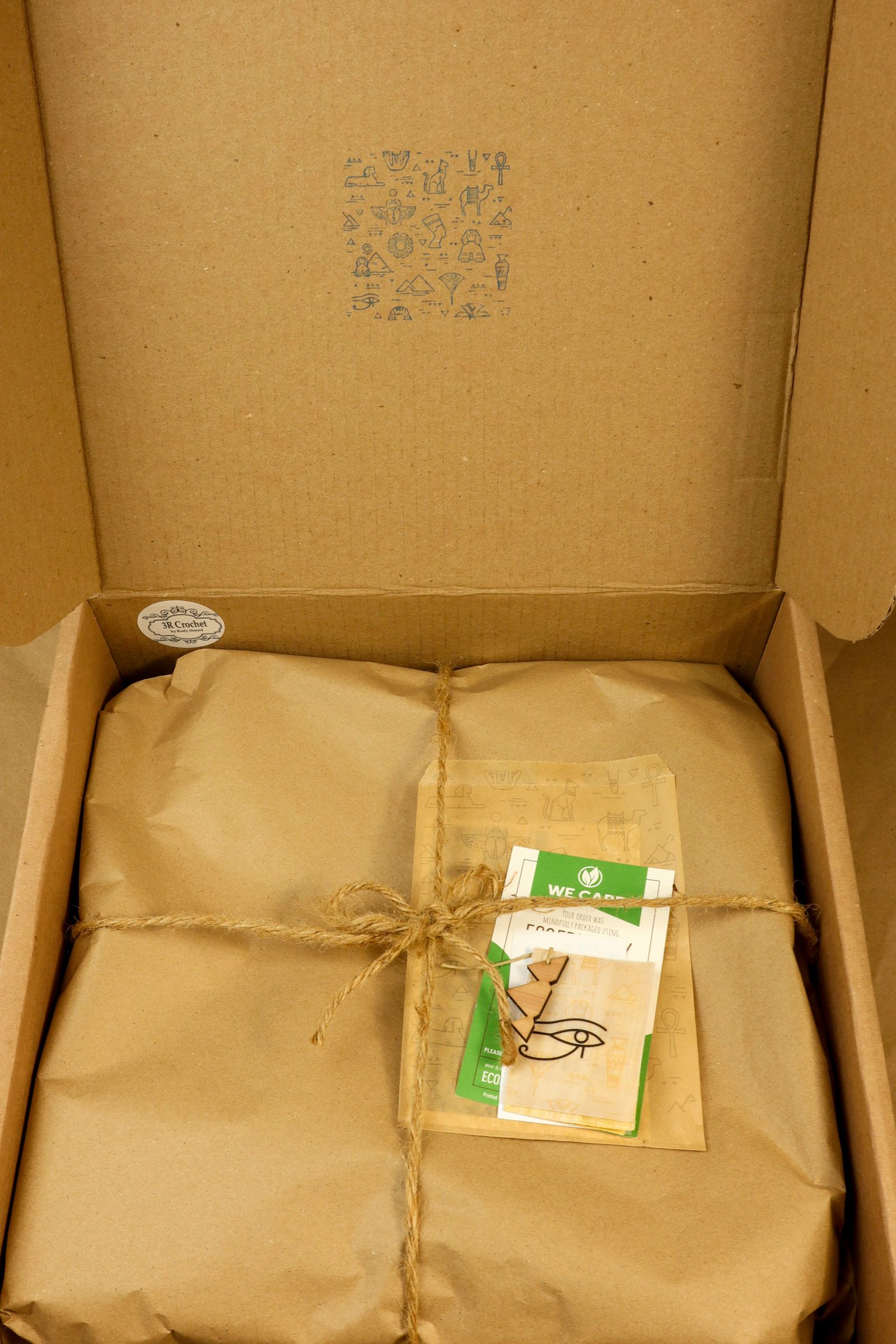 Paper-wrapped package and twine inside an open cardboard box