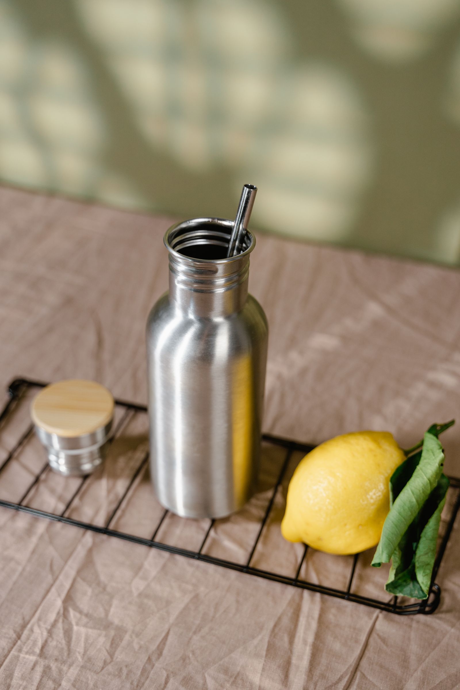 Stainless steel bottle with a lemon on a wire rack
