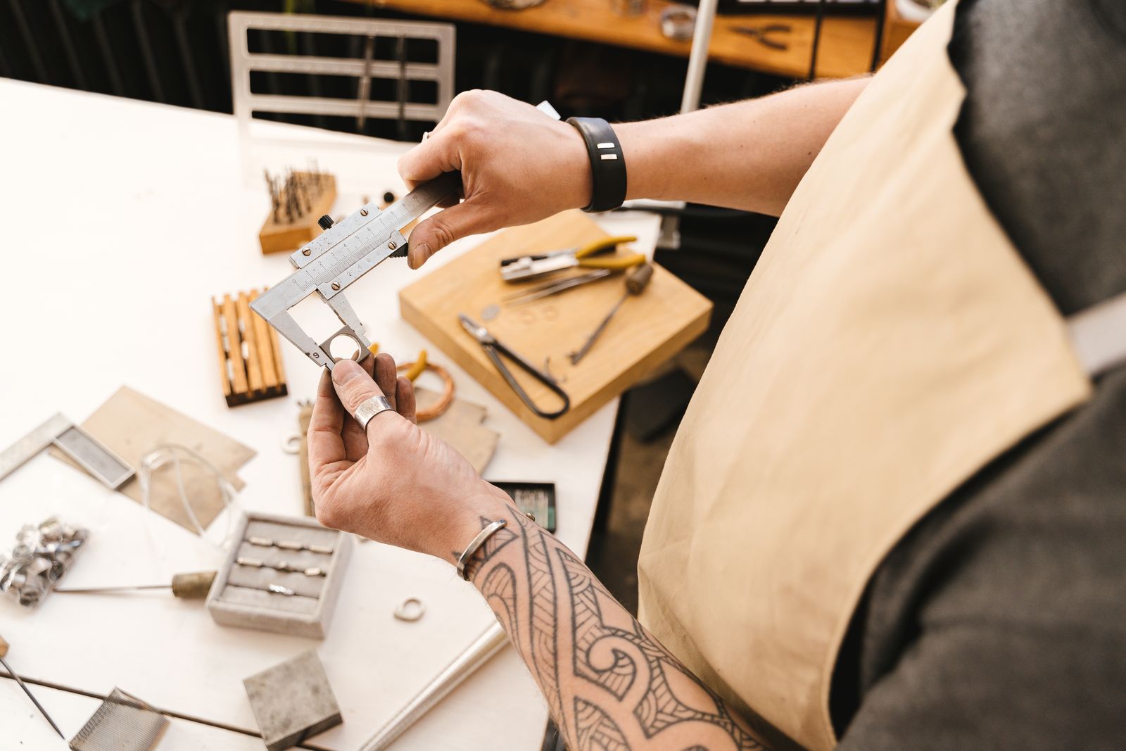 Hands use a vernier caliper to measure a metal object