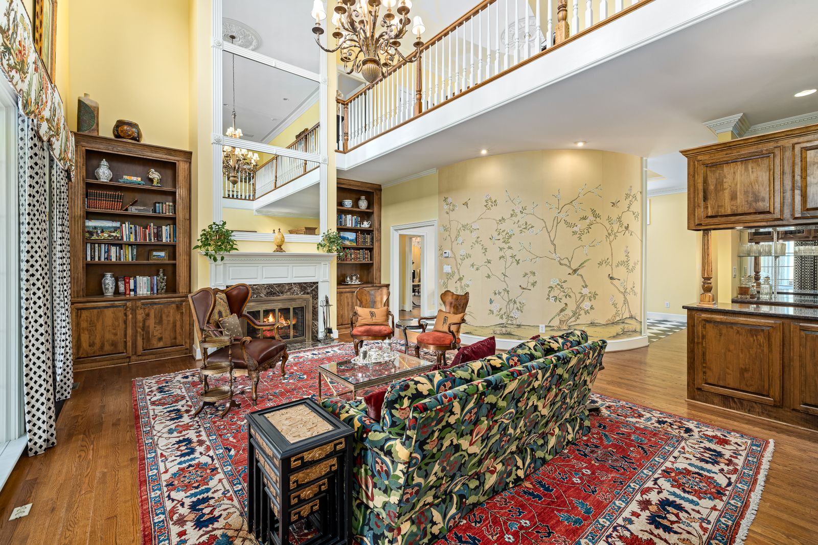 Furnished living room with patterned rug, seating and wooden cabinetry