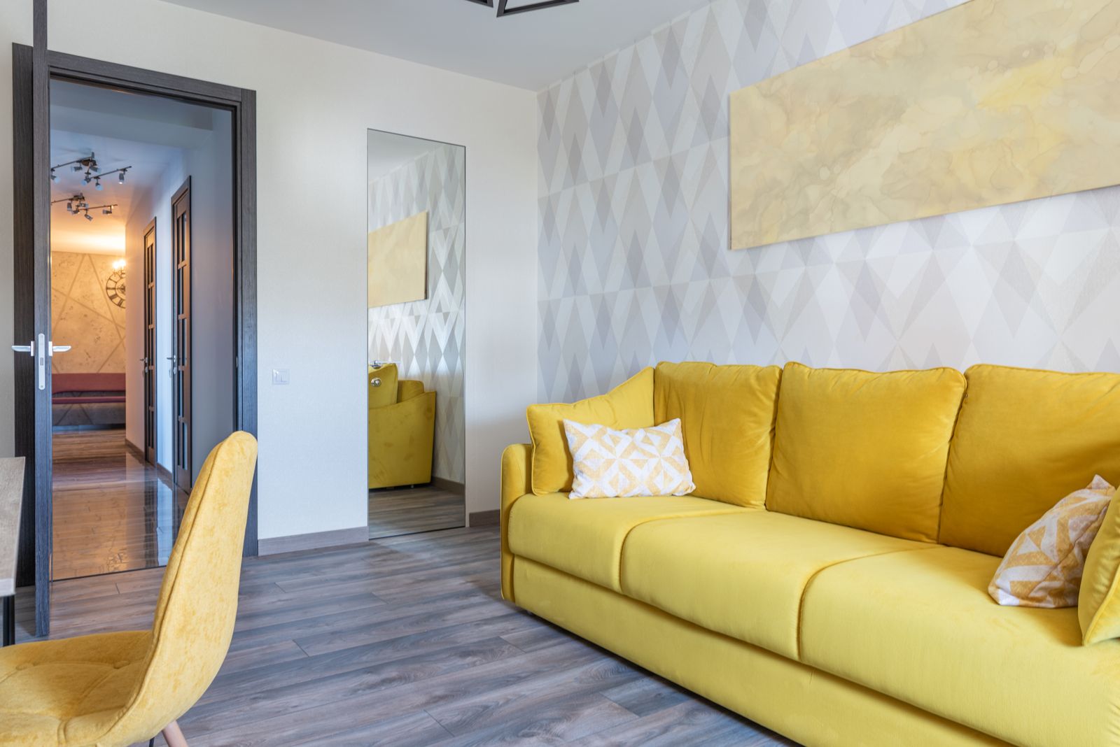 Modern living room with a yellow sofa and a large mirror
