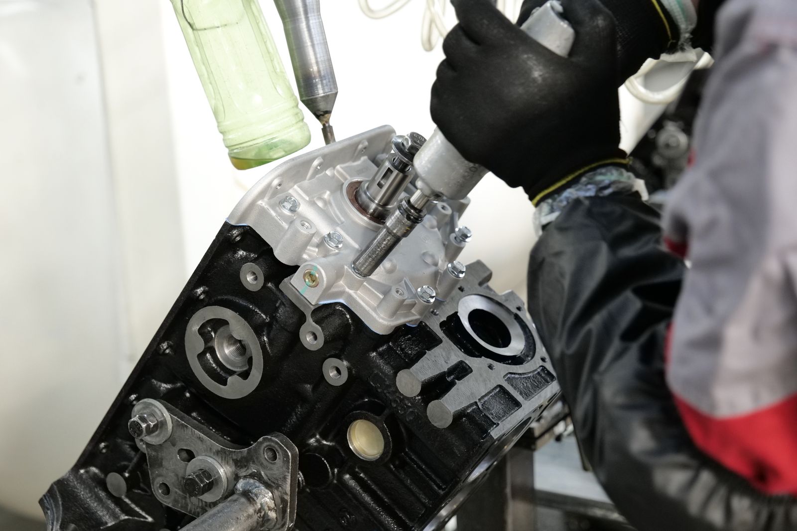 Mechanic works on an engine assembly using precision tools