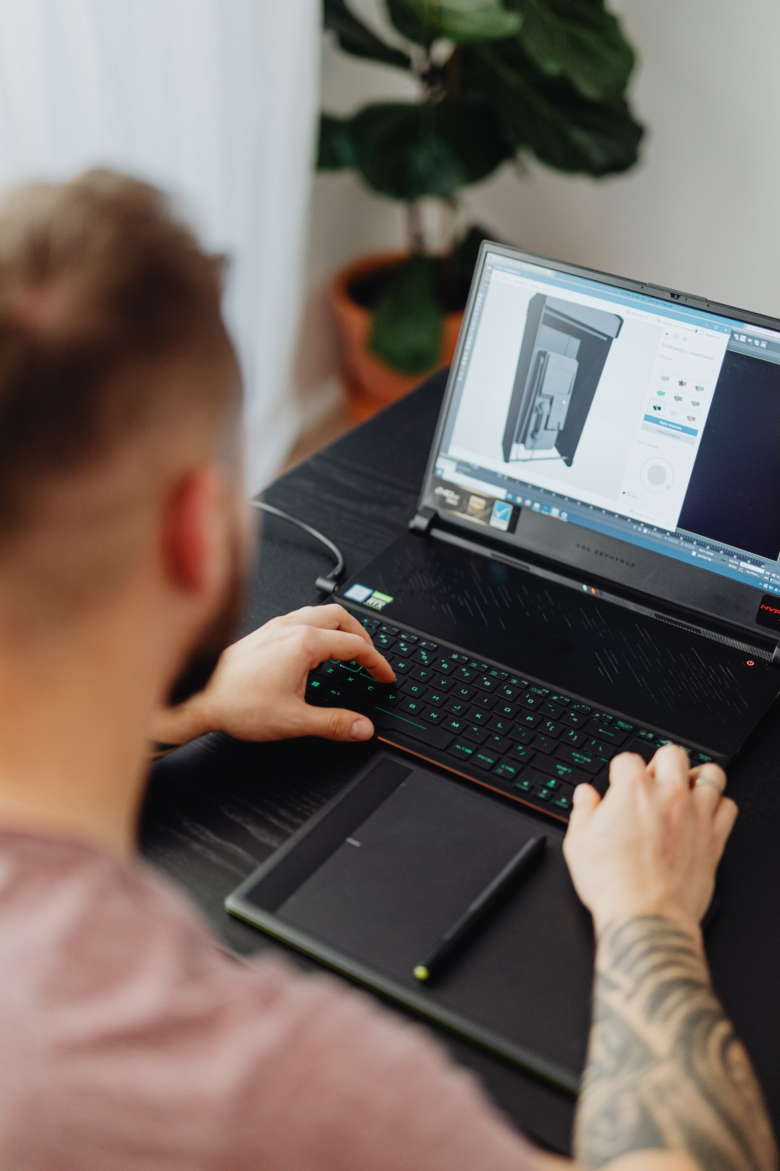 Artist uses a laptop and graphics tablet at a work surface
